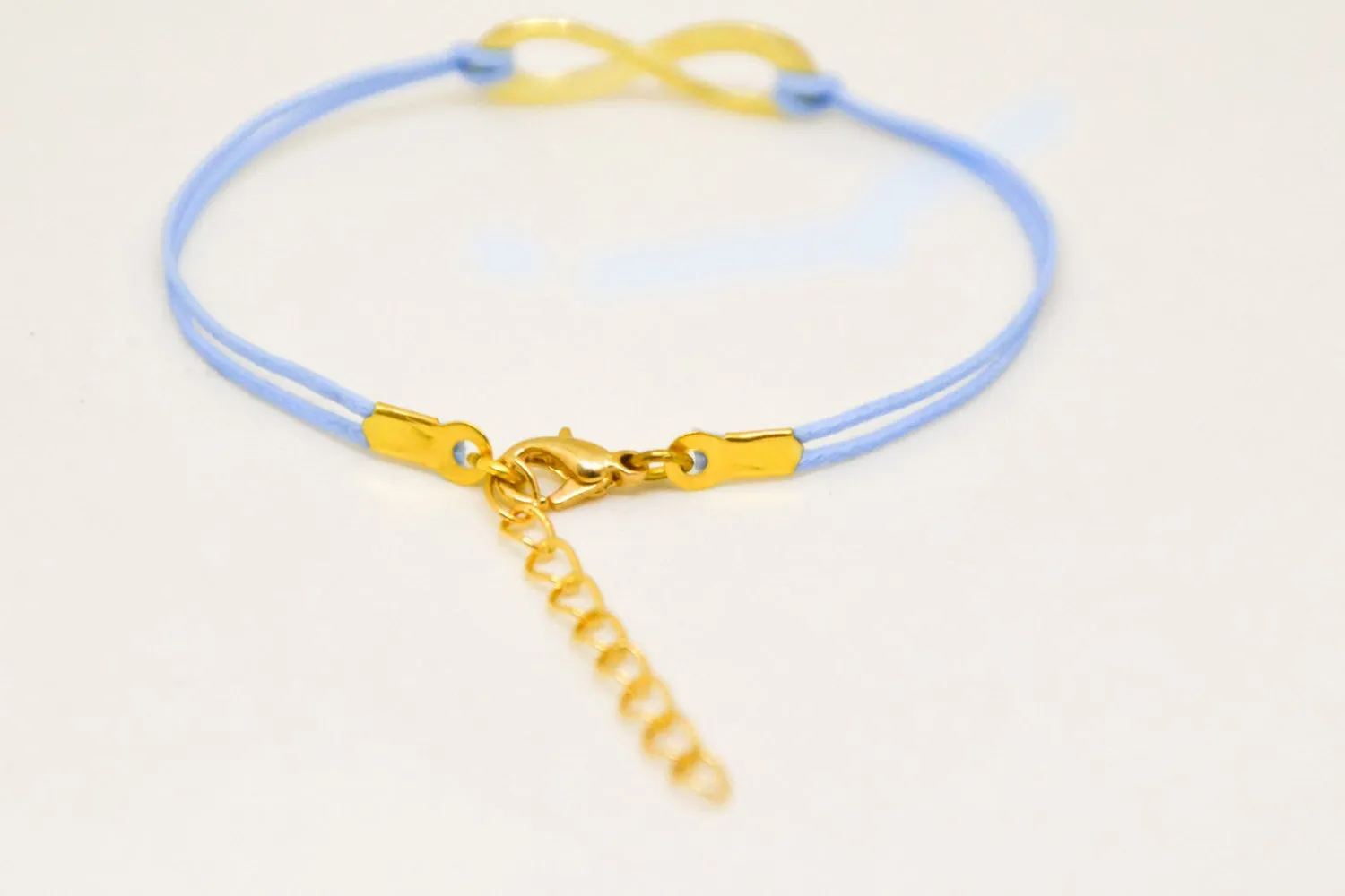 Gold infinity bracelet, womens bracelet with a blue cords, adjustable