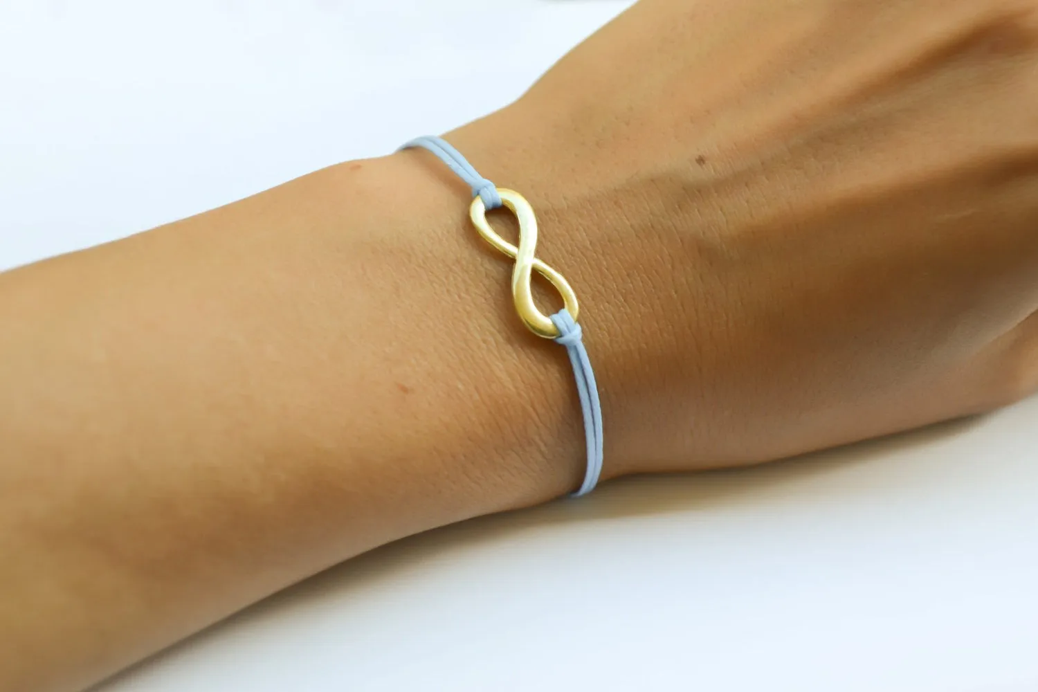 Gold infinity bracelet, womens bracelet with a blue cords, adjustable